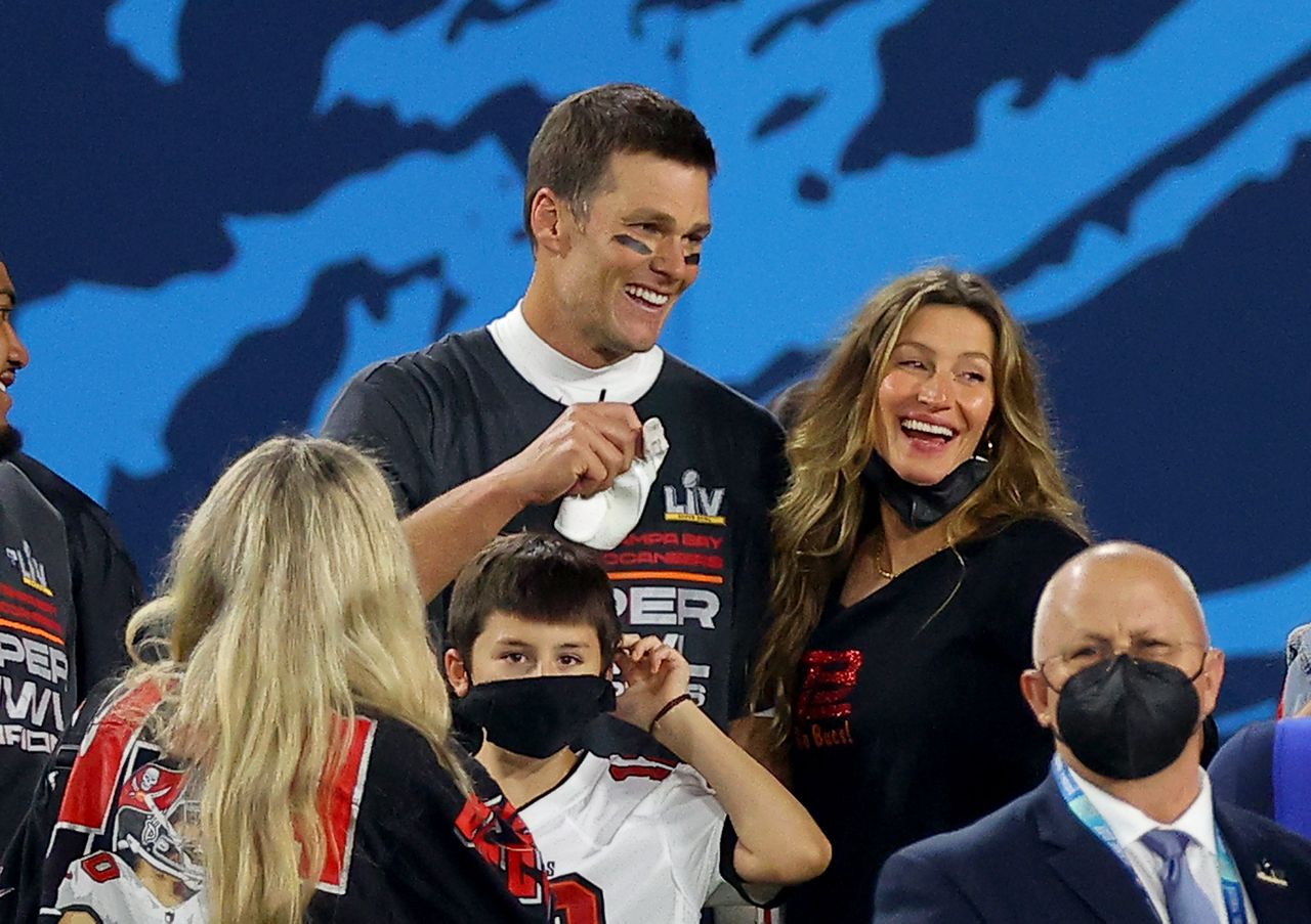Tom Brady and Gisele Bndchen with a group of people at a sports event