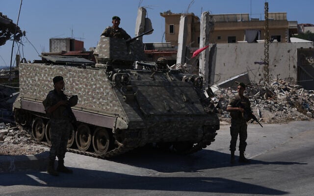 Lebanese soldiers stand beside an armored personnel carrier near buildings damaged during the Israel-Hezbollah war in Ghandouriyeh village, southern Lebanon, July 21, 2026. (Hassan Ammar/AP)