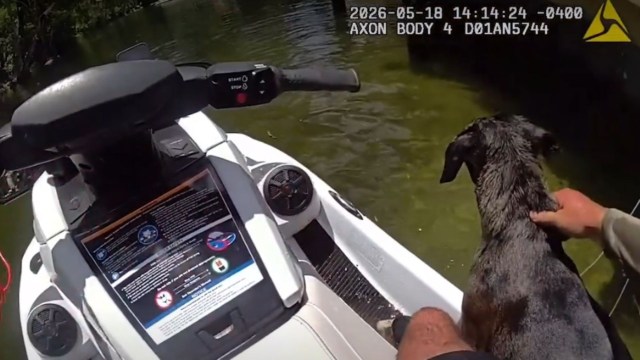 Deputy Shafer holding the dog on a jet ski.