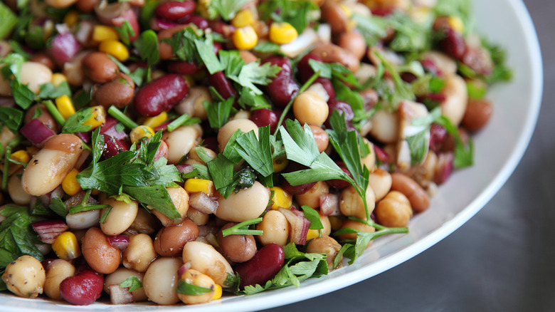 A plate of tri-color bean salad topped with fresh parsley