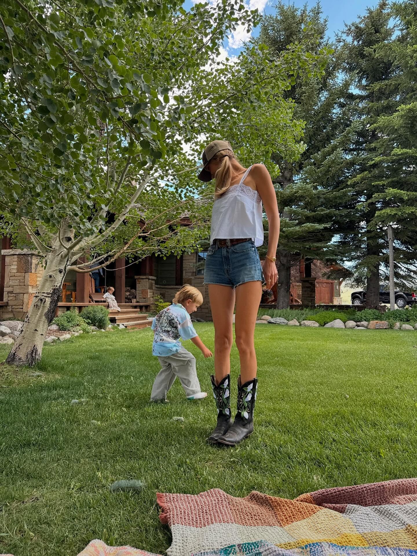 Bella Hadid styled summer-to-fall transition boots with denim shorts and a lacy tank top