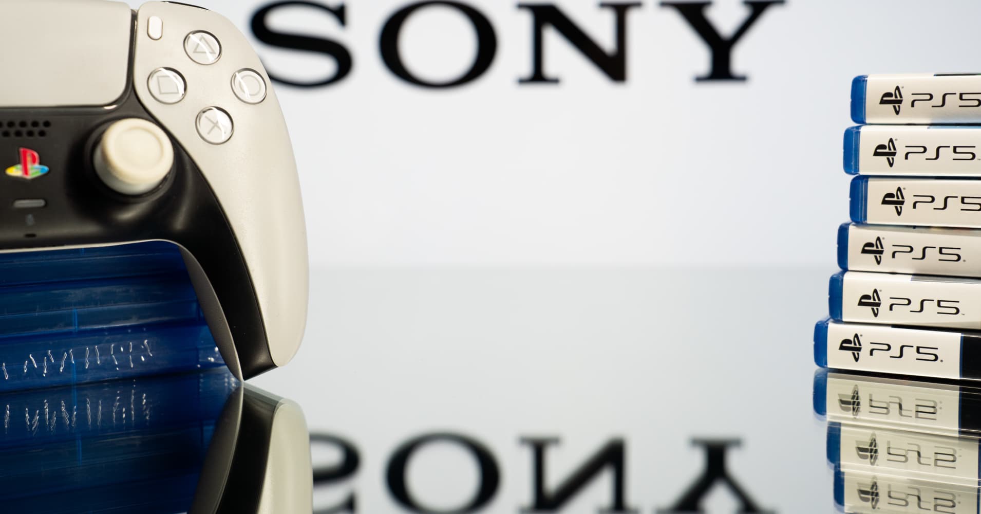 A PlayStation 5 DualSense controller and a stack of retail game cases are seen, with the Sony logo displayed on a screen in the background, in Athens, Greece, on July 14, 2026. Sony Interactive Entertainment announced that it will permanently discontinue the production of physical discs for all new PlayStation games at the end of 2027. Starting in January 2028, all newly released video games will be available exclusively in digital formats and will be available for purchase via the PlayStation Store. (Photo by Nikos Pekiaridis/NurPhoto via Getty Images)