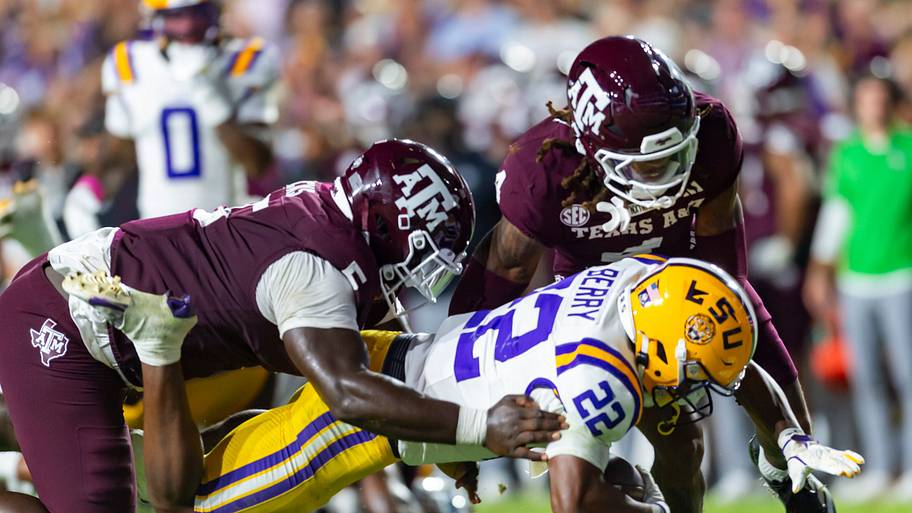 Harlem Berry is tackled by Aggie defenders.