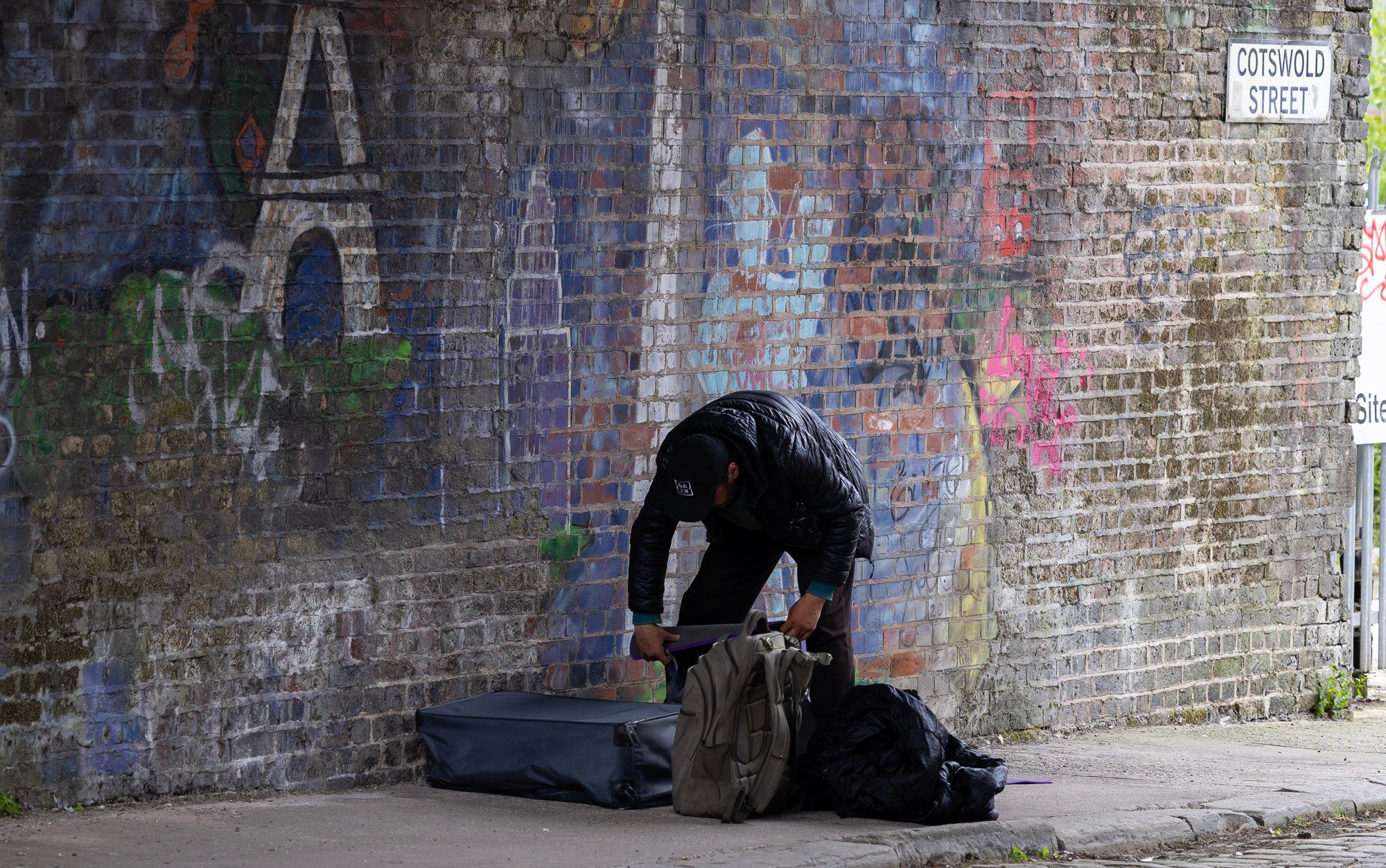 A homeless man sets up his shelter on a Manchester street