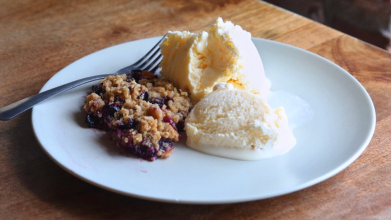 Fruit crumble on plate with ice cream and fork