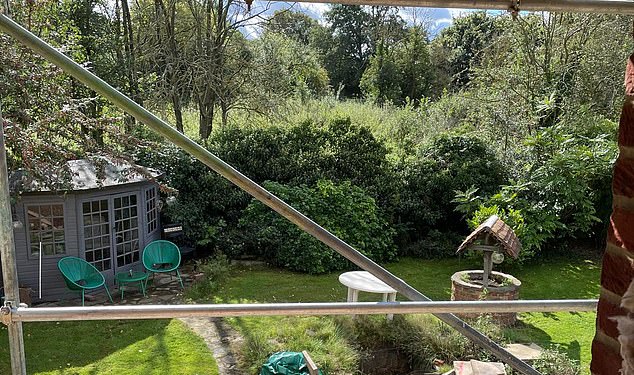 The site, pictured through scaffolding from a neighbouring cottage, was previously filled with greenery