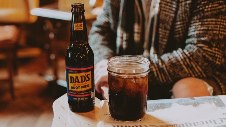 A bottle of Dad's Old Fashioned Root Beer poured into a glass