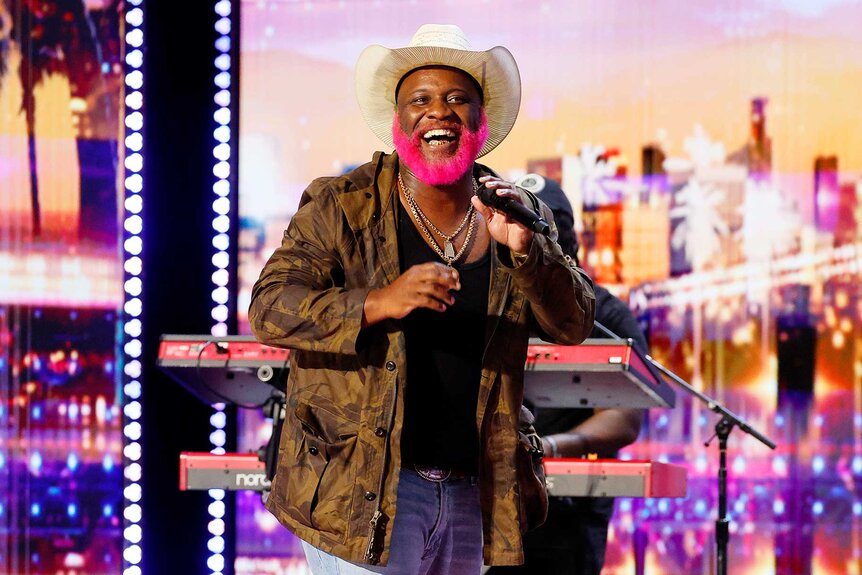 Pynk Beard performing on stage with a microphone on America's Got Talent Season 21 Episode 7.