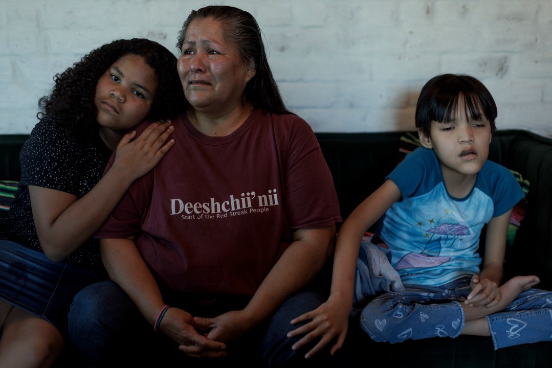 Mother and two kids sitting on a couch