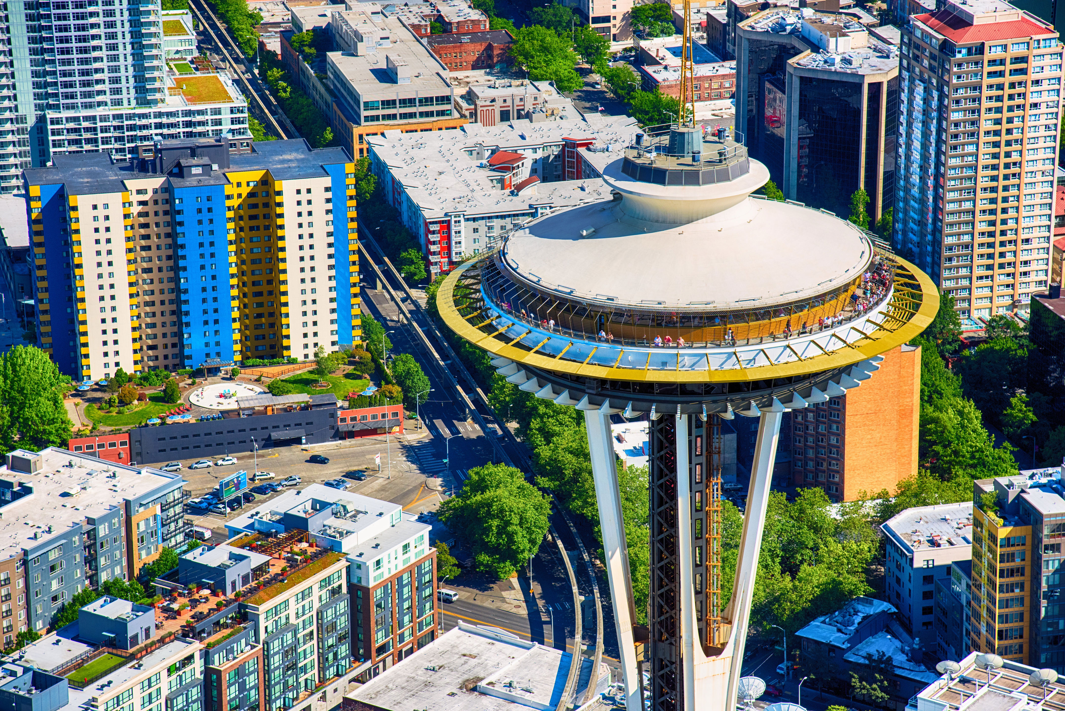Aerial view of the Space Needle surrounded by urban buildings in Seattle, highlighting its iconic architecture and vibrant cityscape