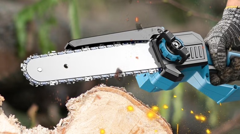 Person cutting a log with a mini chainsaw