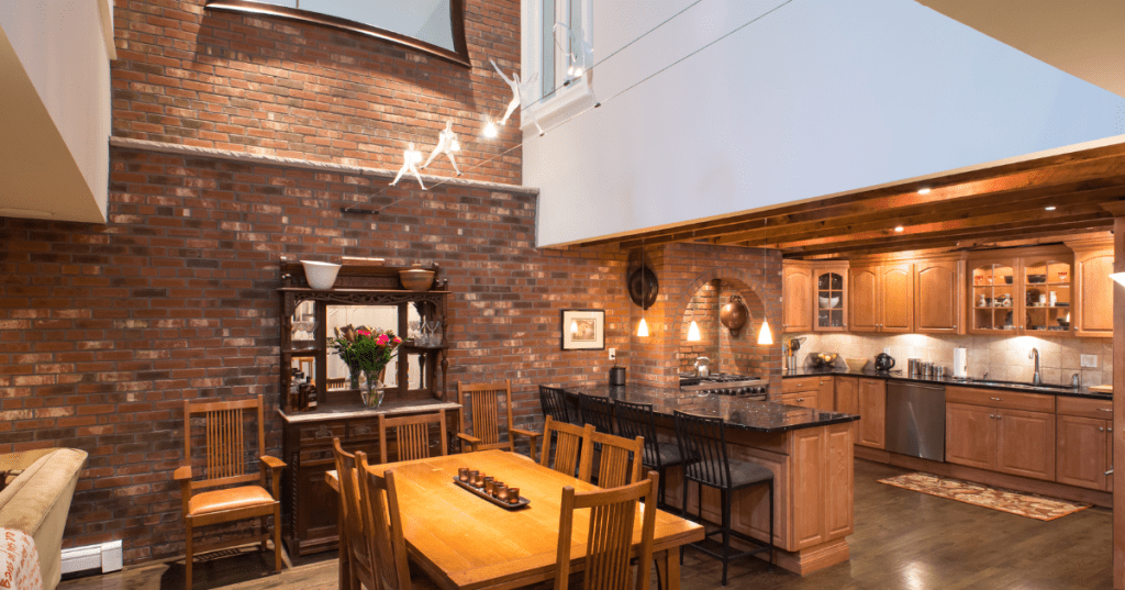 The brick interior of a historic Airbnb in Boston, Massachusetts, featuring vaulted ceilings and a big kitchen.