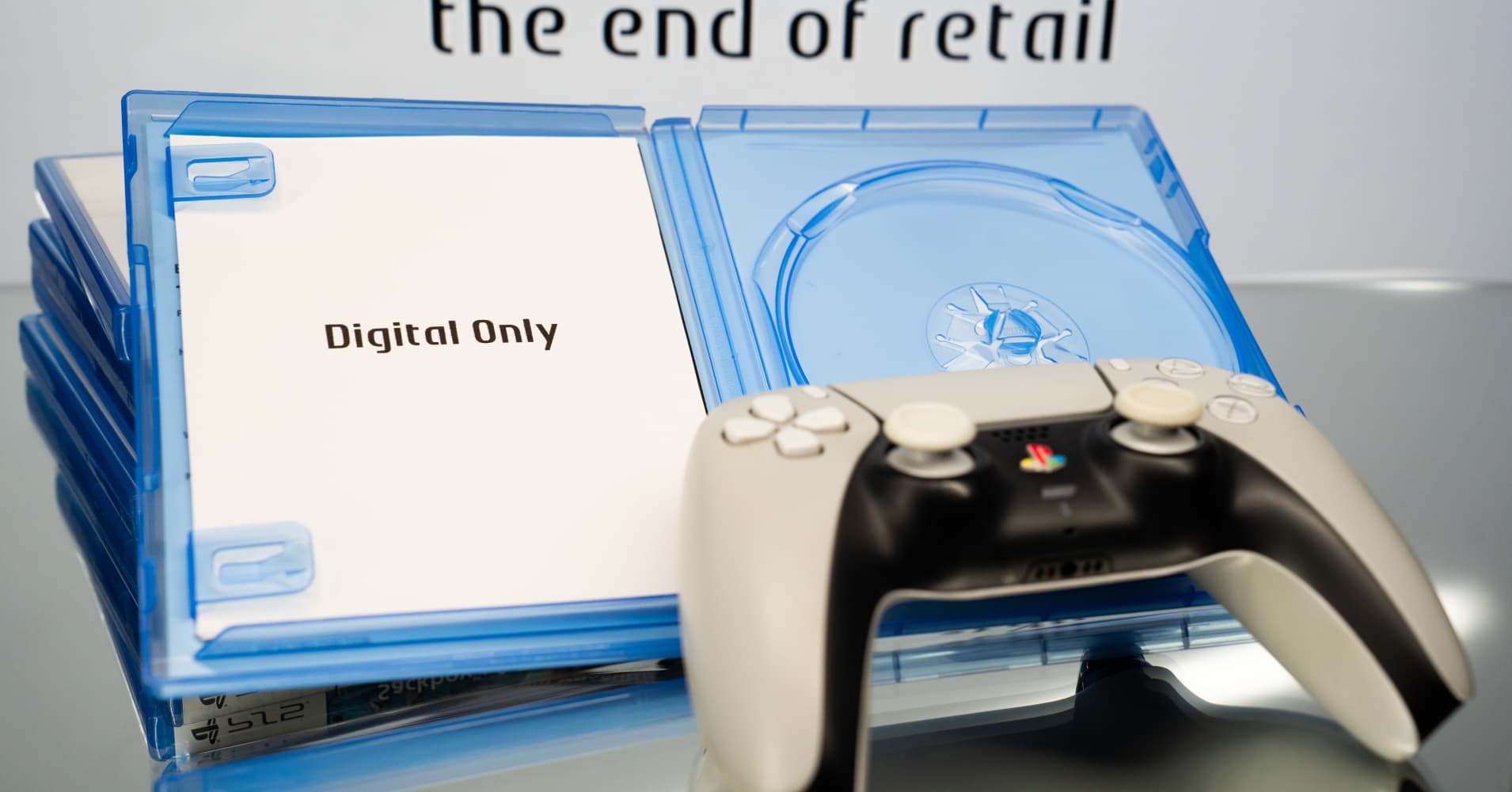 A PlayStation 5 controller and an open, empty retail game case containing a card that reads ''Digital Only'' are seen, with the text ''the end of retail'' displayed on a screen in the background, in Athens, Greece, on July 14, 2026. Sony Interactive Entertainment announced that it will permanently discontinue the production of physical discs for all new PlayStation games at the end of 2027.