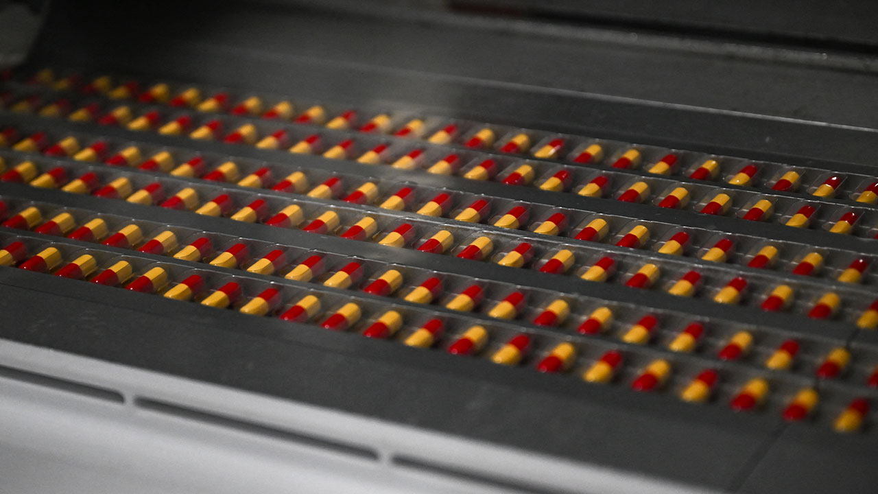 Capsules move along a pharmaceutical manufacturing production line