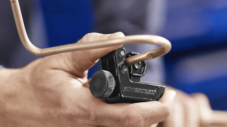 A person using tubing cutter