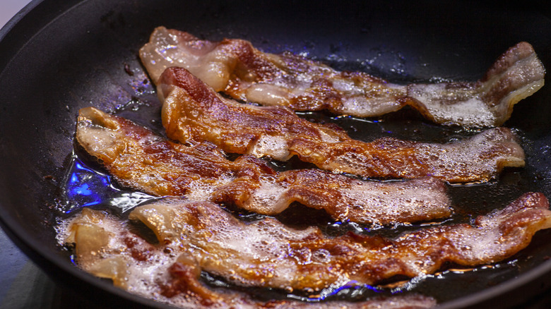 bacon frying in a cast iron pan