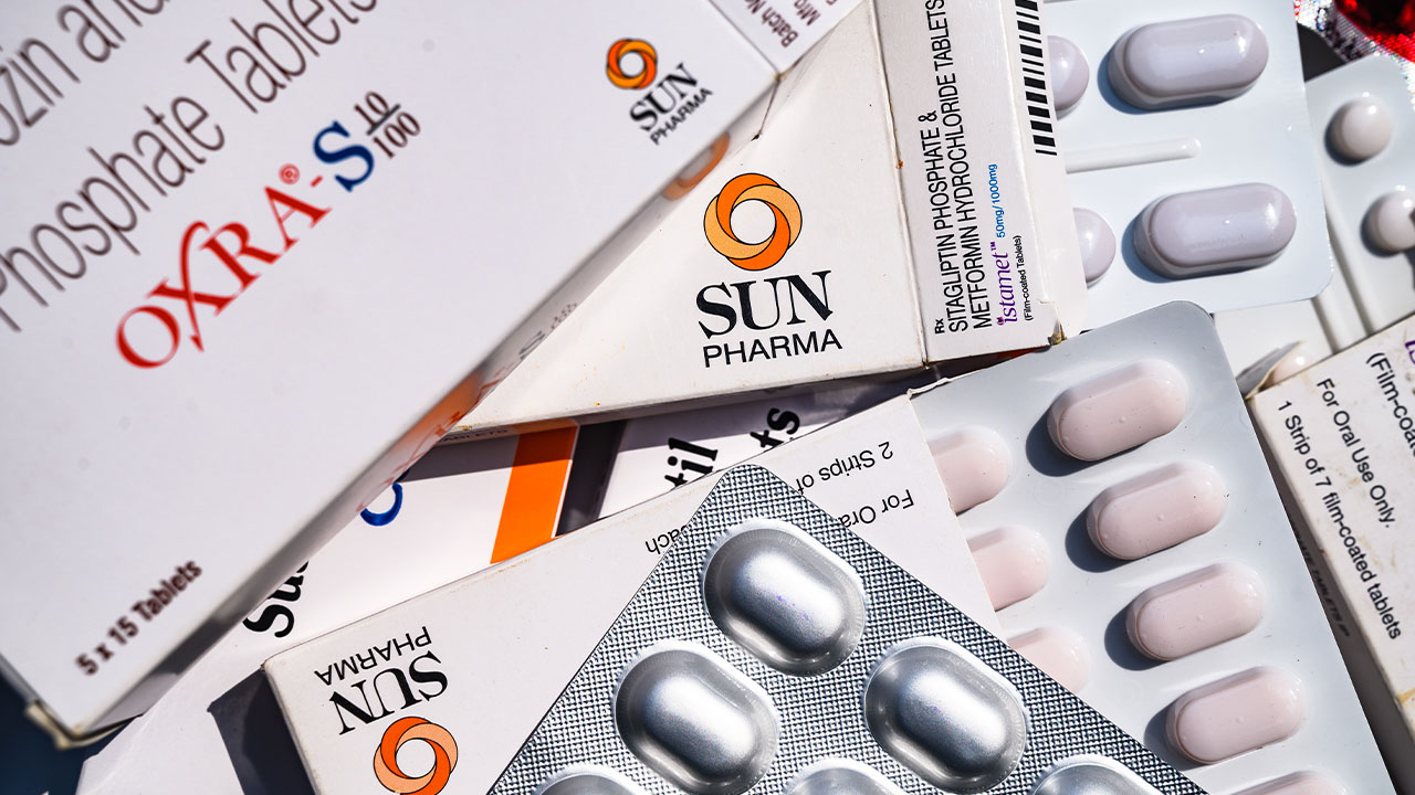 Boxes of generic prescription medications and blister packs of tablets are displayed together