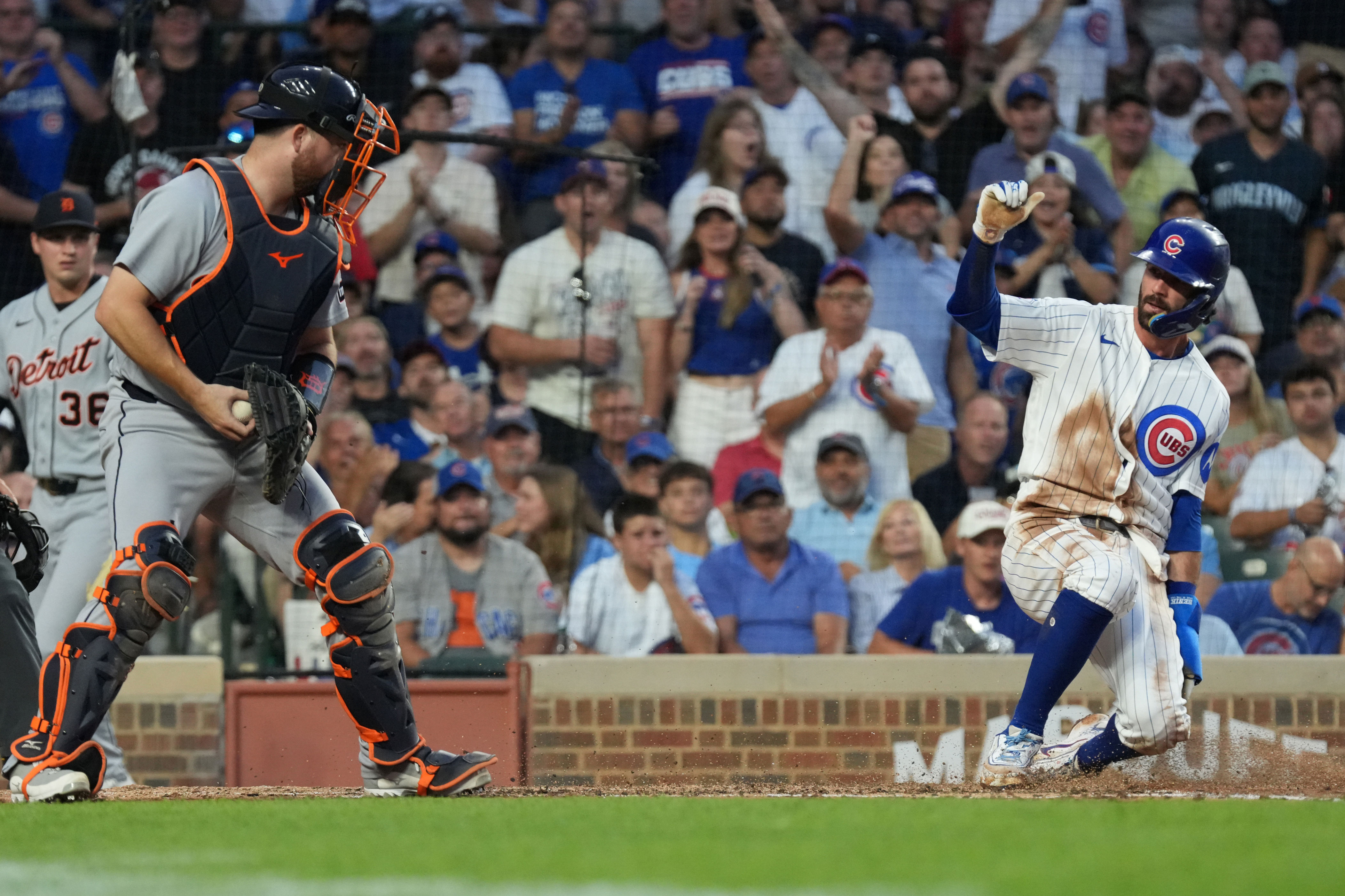 Chicago Cubs' Dansby Swanson, right, is safe at home plate as Detroit Tigers catcher Jake Rogers, left takes a late throw during the third inning of a baseball game Tuesday, July 21, 2026, in Chicago. (AP Photo/David Banks)