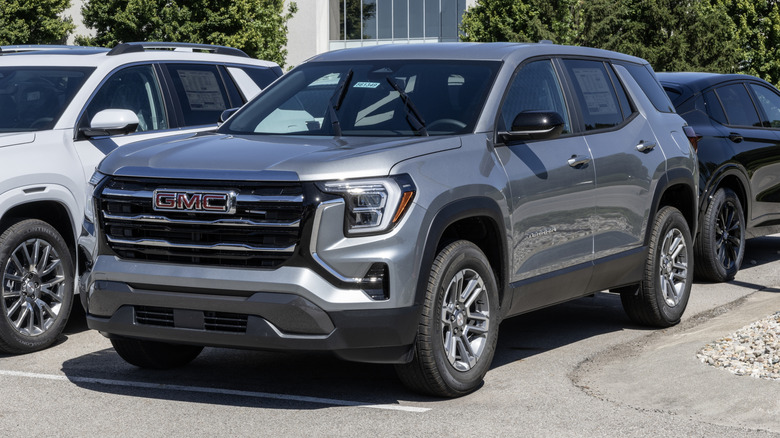 A silver GMC Terrain Elevation FWD Small SUV at a dealership.