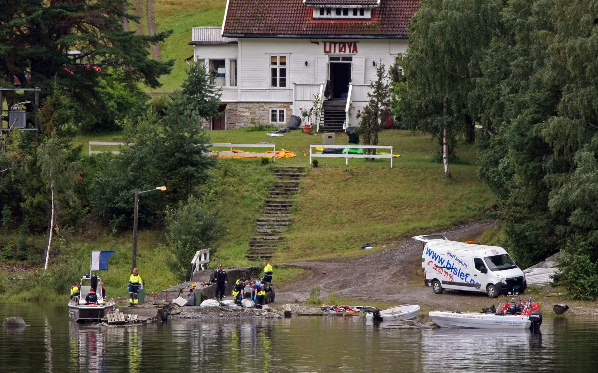 Bodies being reocvered from thw water with the main school building behind. There are people in high vis jackets.