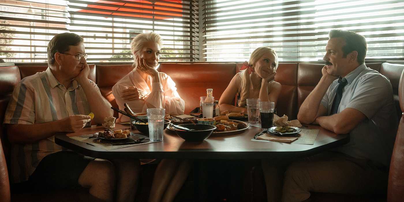 Ted sitting with Higgins, Rebecca, and Keeley at a barbecue shop in Kansas in Ted Lasso.