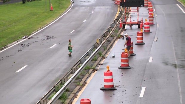 Man and child kick soccer ball on closed down roadway