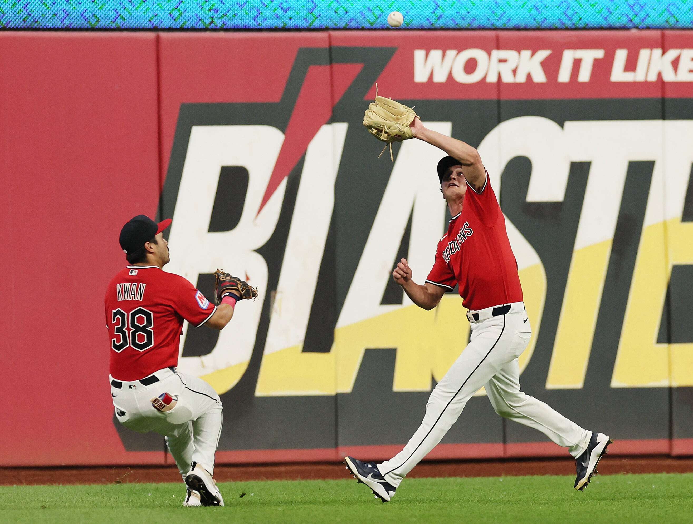 Cleveland Guardians center fielder Petey Halpin runs down a deep fly ball off the bat of Minnesota Twins first baseman Victor Caratini as Cleveland Guardians left fielder Steven Kwan converges on the play in the ninth inning.