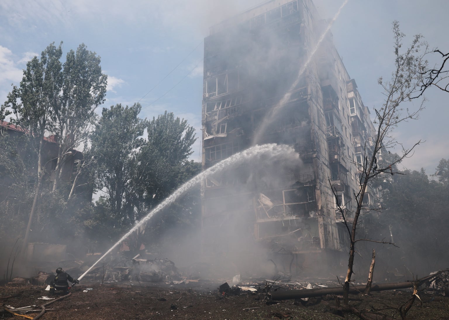 Rescue workers attempt to put out a fire at a residential building after a Russian air guided bomb strike in Zaporizhzhia, Ukraine (Kateryna Klochko/AP)