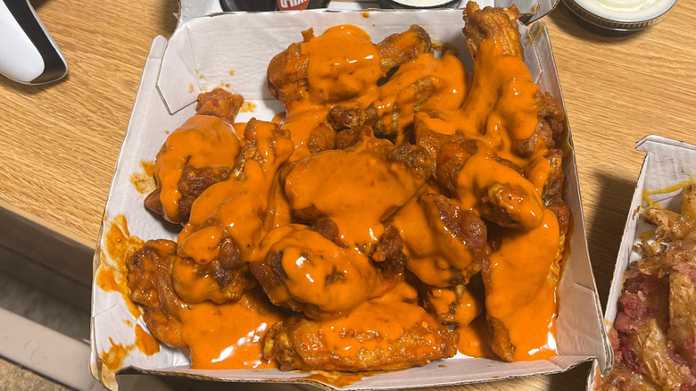 A basket of extra wet wings at Buffalo Wild Wings completely smothered in sauce