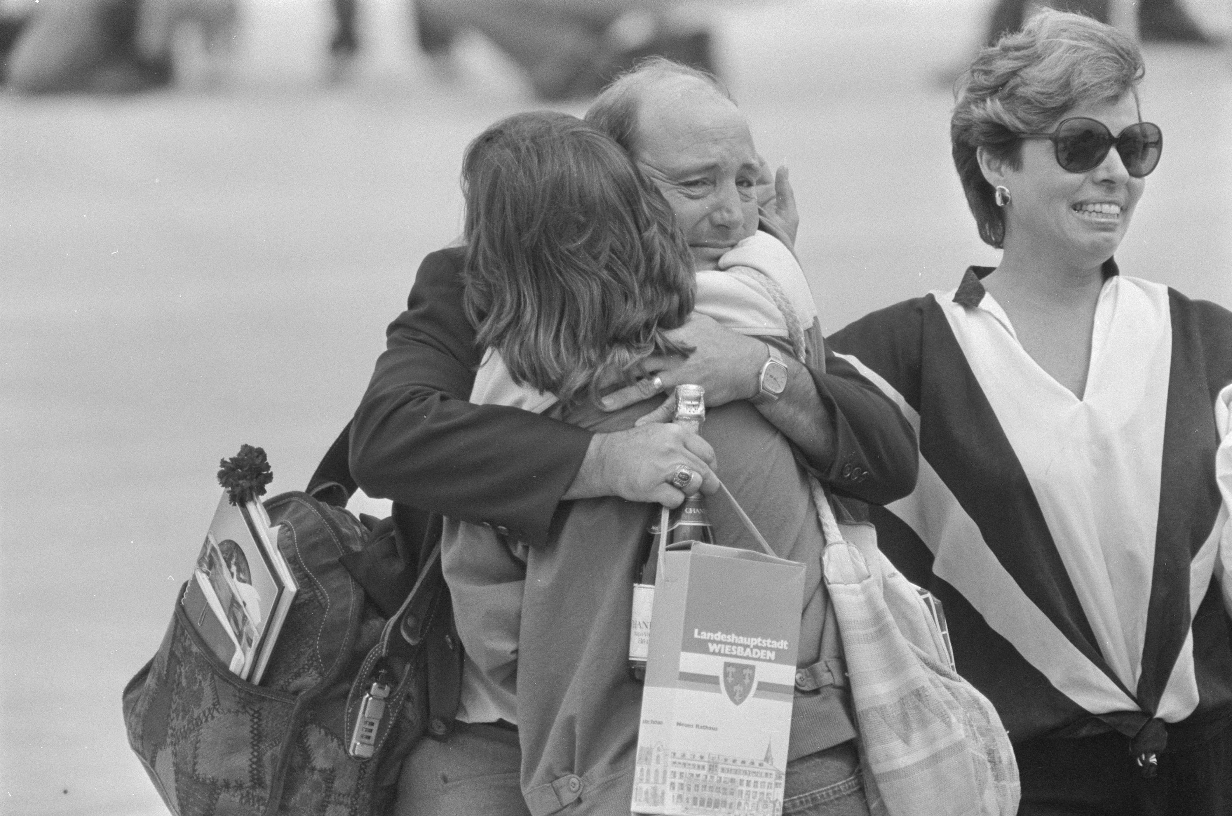 One of the 39 freed American hostages from TWA Flight 847, clutching a bottle of champagne, embraces a relative at Andrews Air Force Base in Maryland, U.S., July 2, 1985. REUTERS/Bill Creighton 85238009 / Bill Creighton / REUTERS