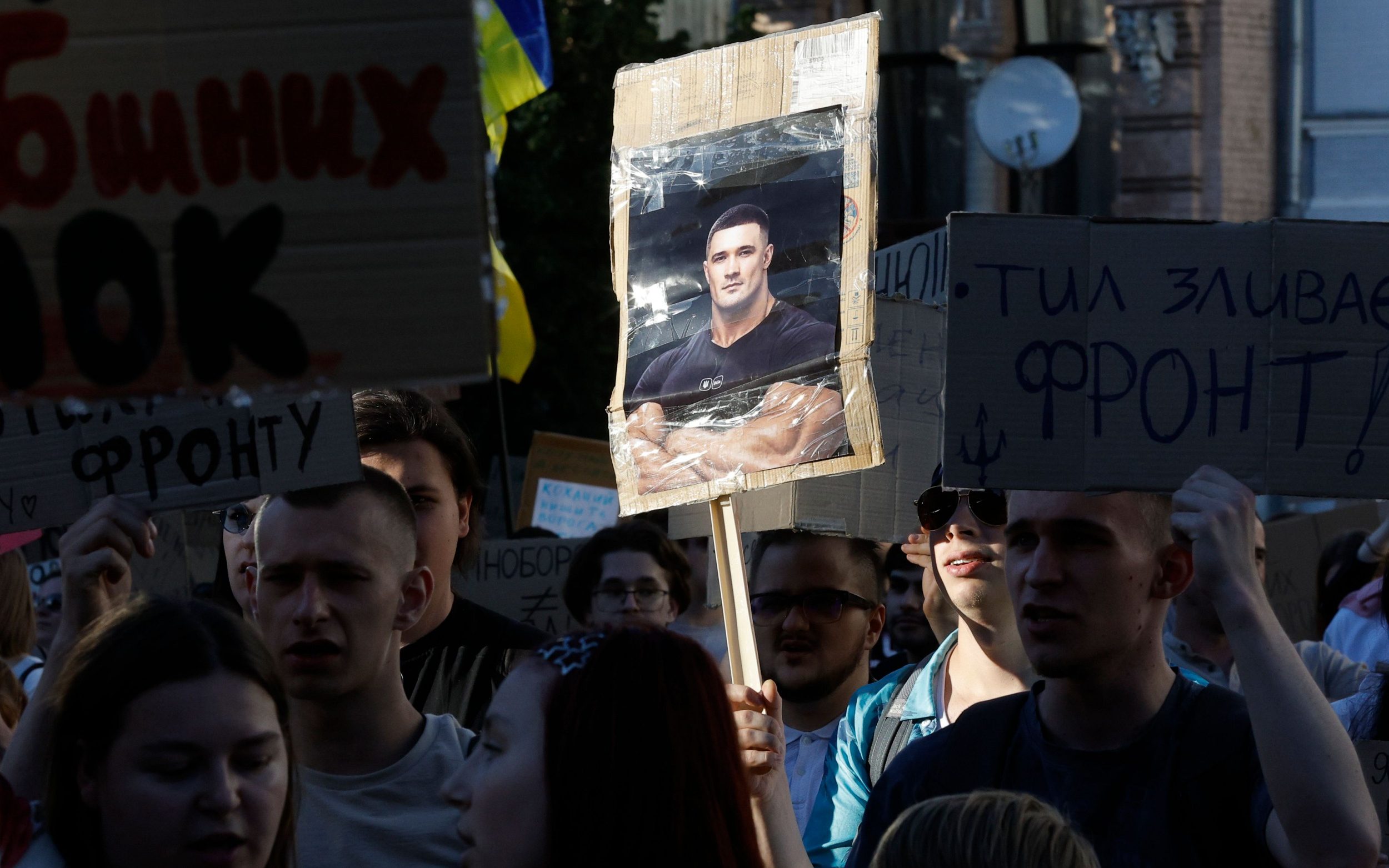 A protester carries a banner with a photograph of Mykhailo Fedorov during the demonstrations in Kyiv