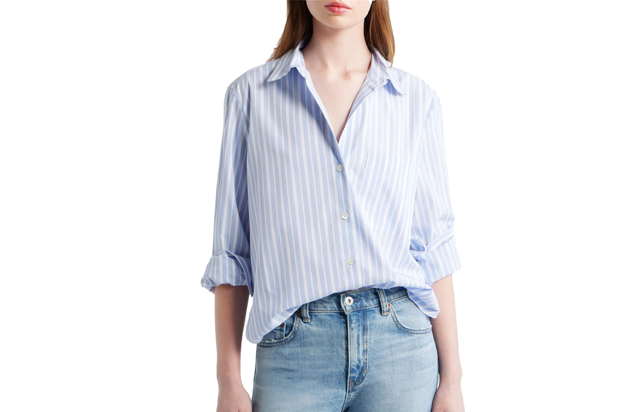 A model wearing a light blue and white striped button-up shirt with sleeves rolled up and light wash denim jeans.