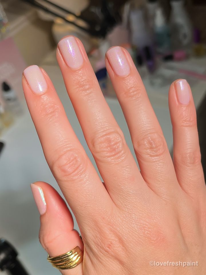 A hand with neatly manicured nails on a blurred background