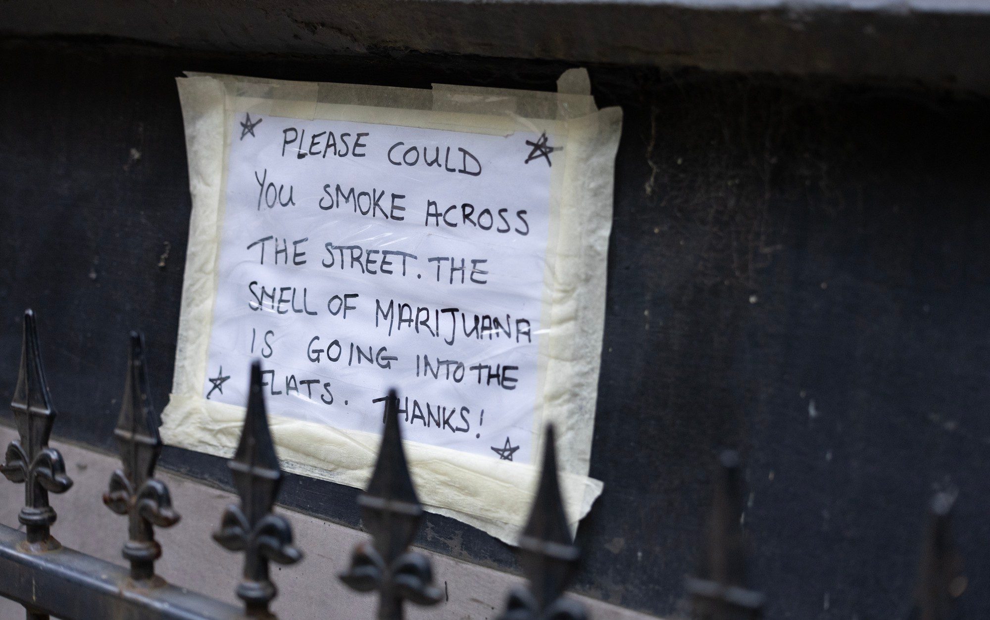 A poster asking for people to stop smoking marijuana near a block of flats