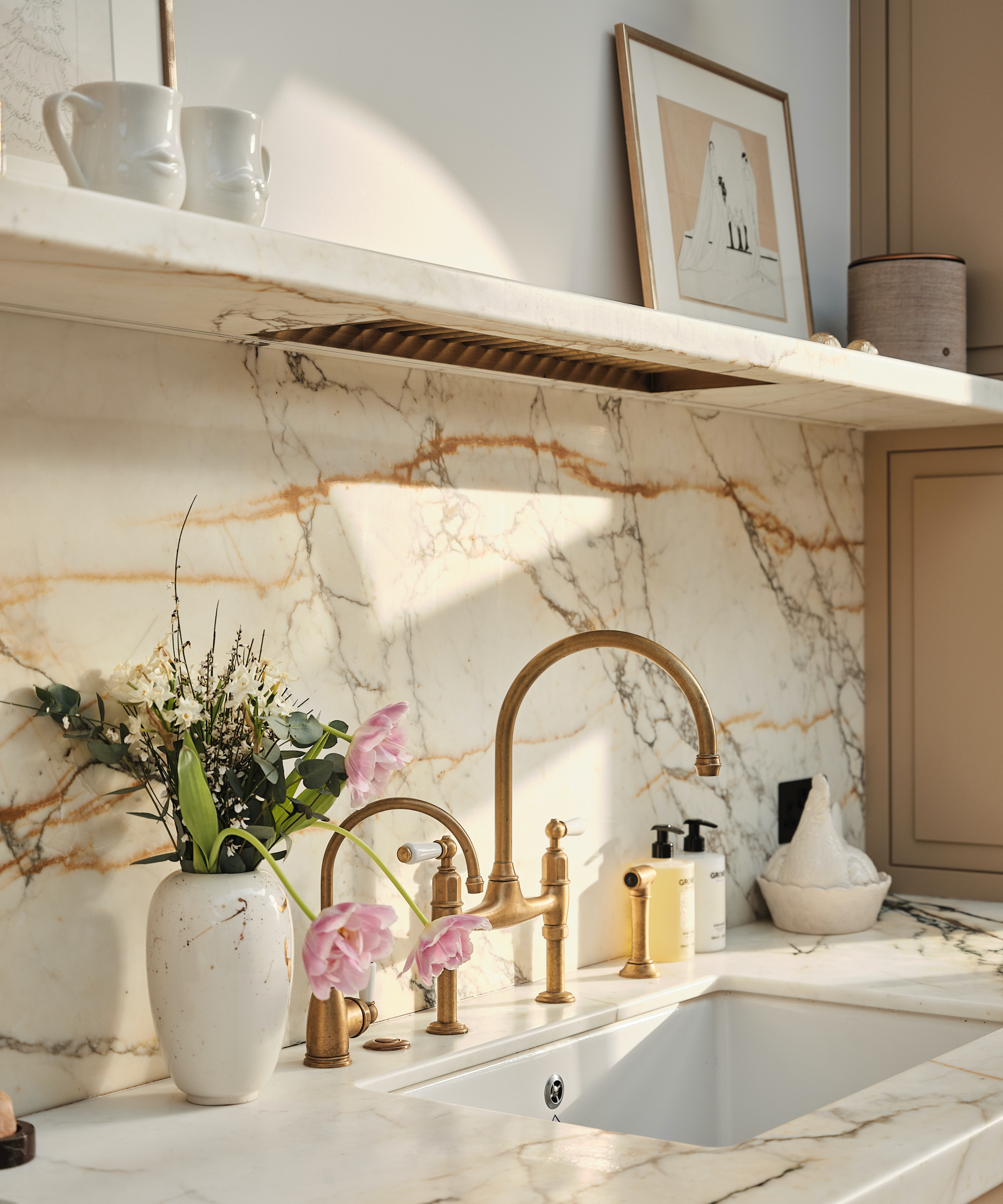 white ceramic sink with brass taps and marble worktops