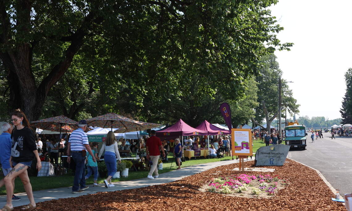 Visitors walk on the path along the Art in the Park booths.