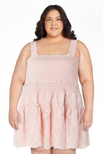 Person wearing a sleeveless dress with ruffled details, suitable for casual and summer outings