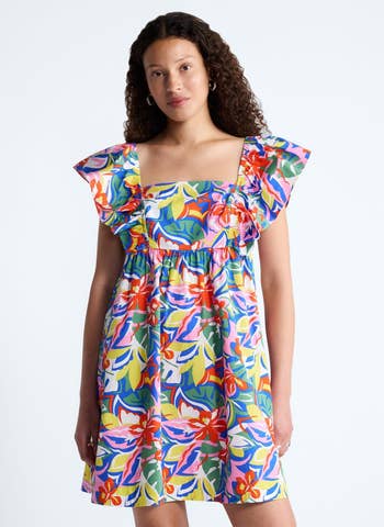 Person wearing a floral-patterned dress with ruffled sleeves