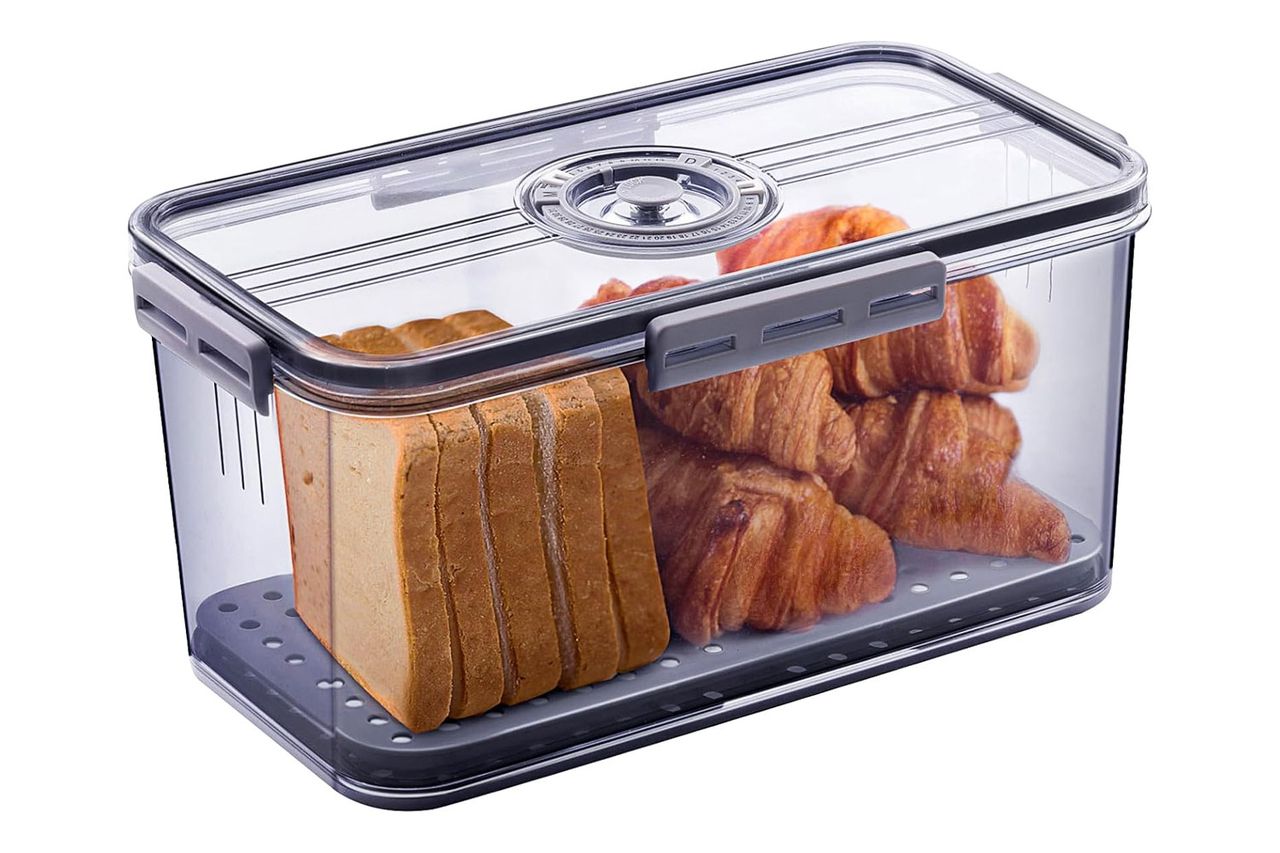 Bread slices and croissants stored in a transparent bread box.