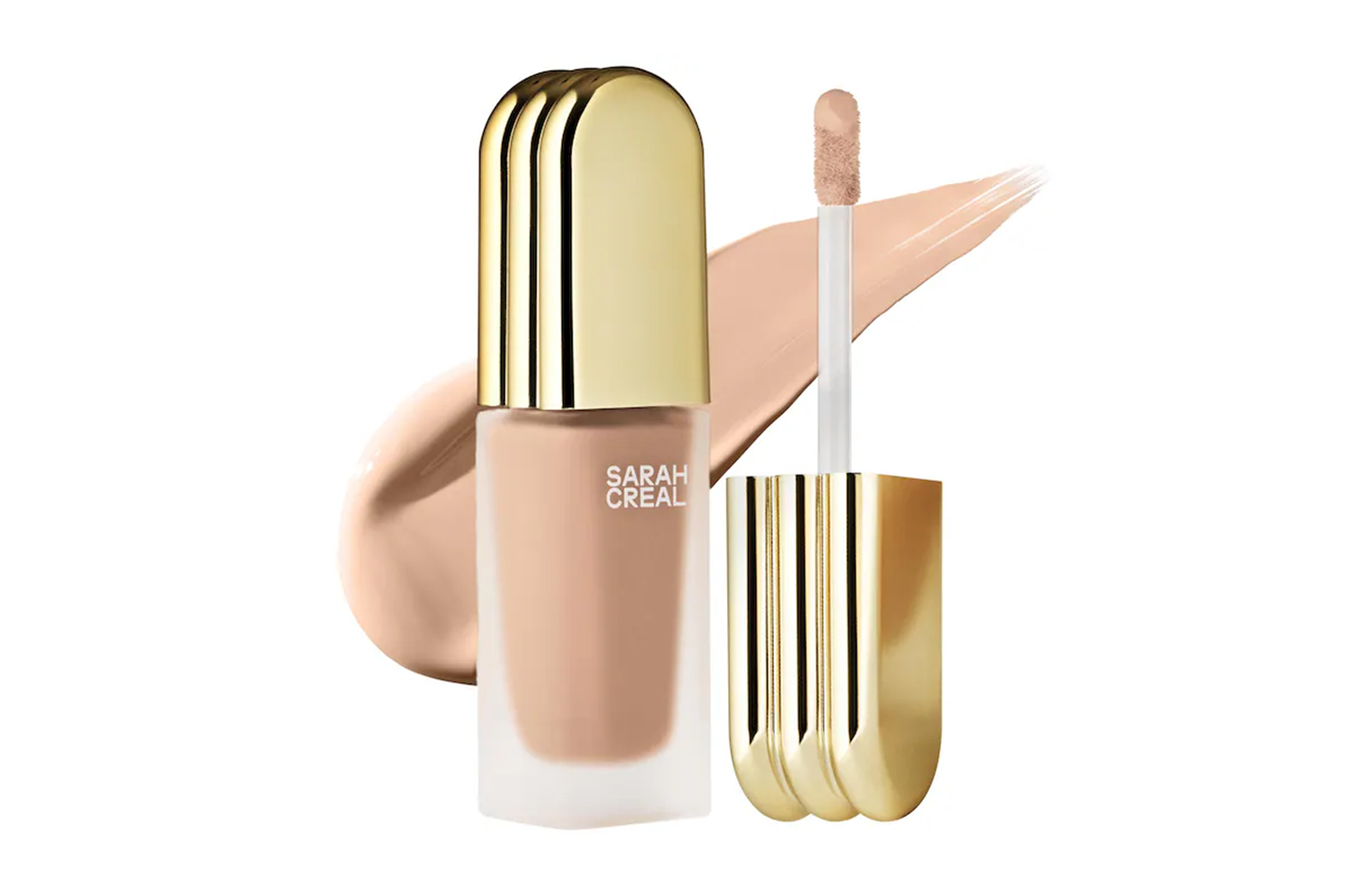 Sarah Creal liquid foundation in a frosted bottle with a golden cap and applicator, with a swatch of the foundation.