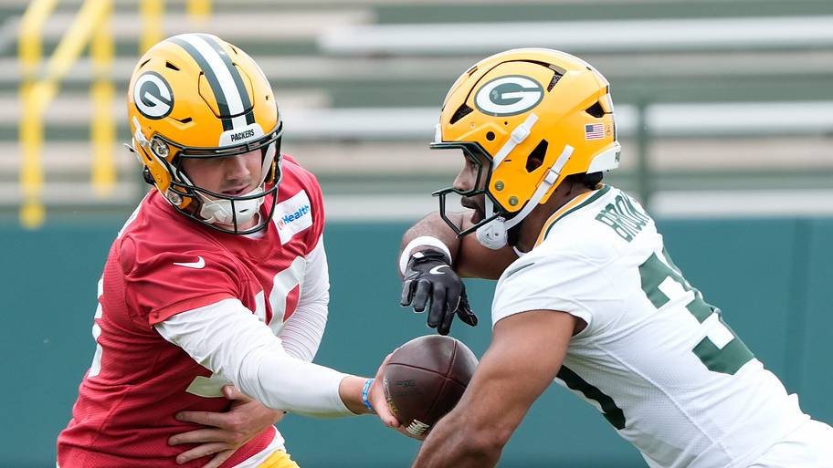 Green Bay Packers Kyle McCord (18) hands off the ball to Chris Brooks (30) during minicamp.