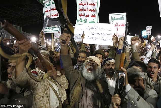 Protesters who support Yemen's Houthi group brandish weapons and shout slogans as they celebrate the ban decision imposed against the maritime shipping of Saudi Arabia