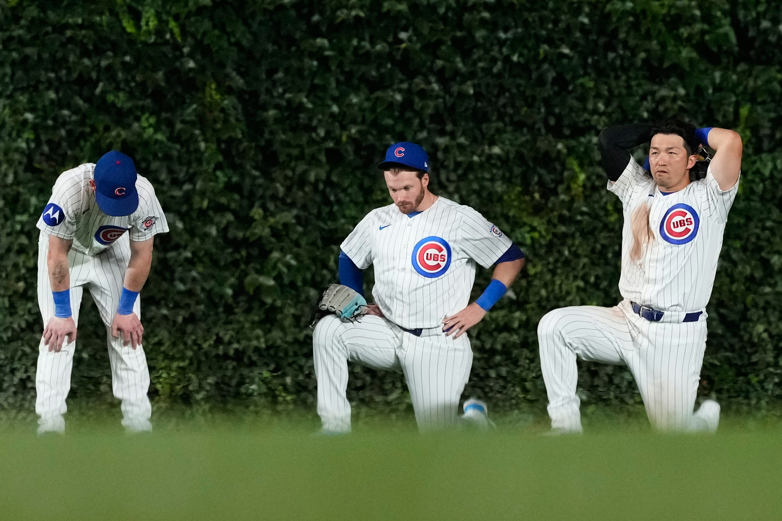 From left, Chicago Cubs center fielder Pete Crow-Armstrong, left fielder Ian Happ, and right fielder Seiya Suzuki, of Japan, react after relief pitcher Trent Thornton left the game after an injury during the 10th inning of a baseball game against the Detroit Tigers in Chicago, Monday, July 20, 2026. (AP Photo/Nam Y. Huh)