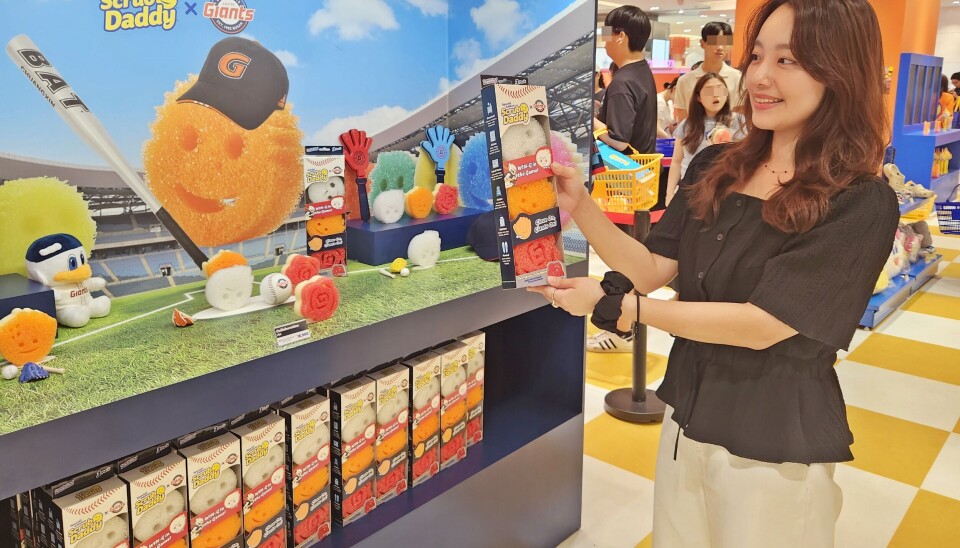 A person holds a package of kitchen sponges produced in collaboration with the Lotte Giants at a department store in Busan on Aug. 11, 2025.