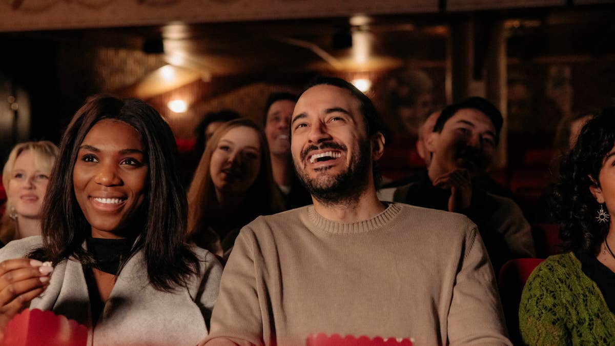 cheerful-multiracial-friends-laughing-while-enjoying-comedy-movie-in-cinema-theater