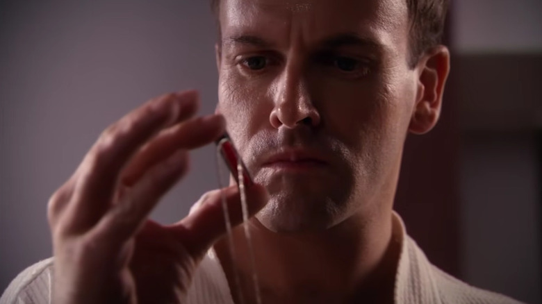 Jordan Chase holding a medallion on Dexter