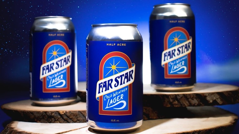 Three cans of Half Acre Far Star Lager on wooden boards