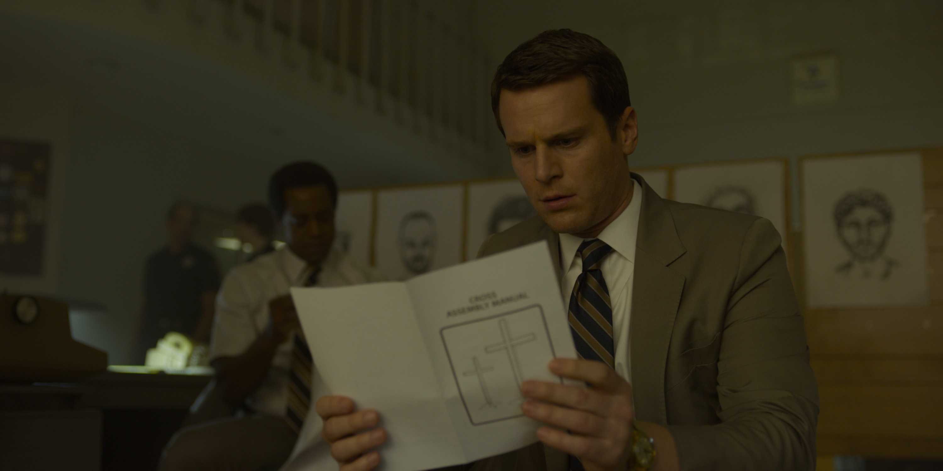 Holden Ford (Jonathan Groff) looking at a pamphlet in Mindhunter