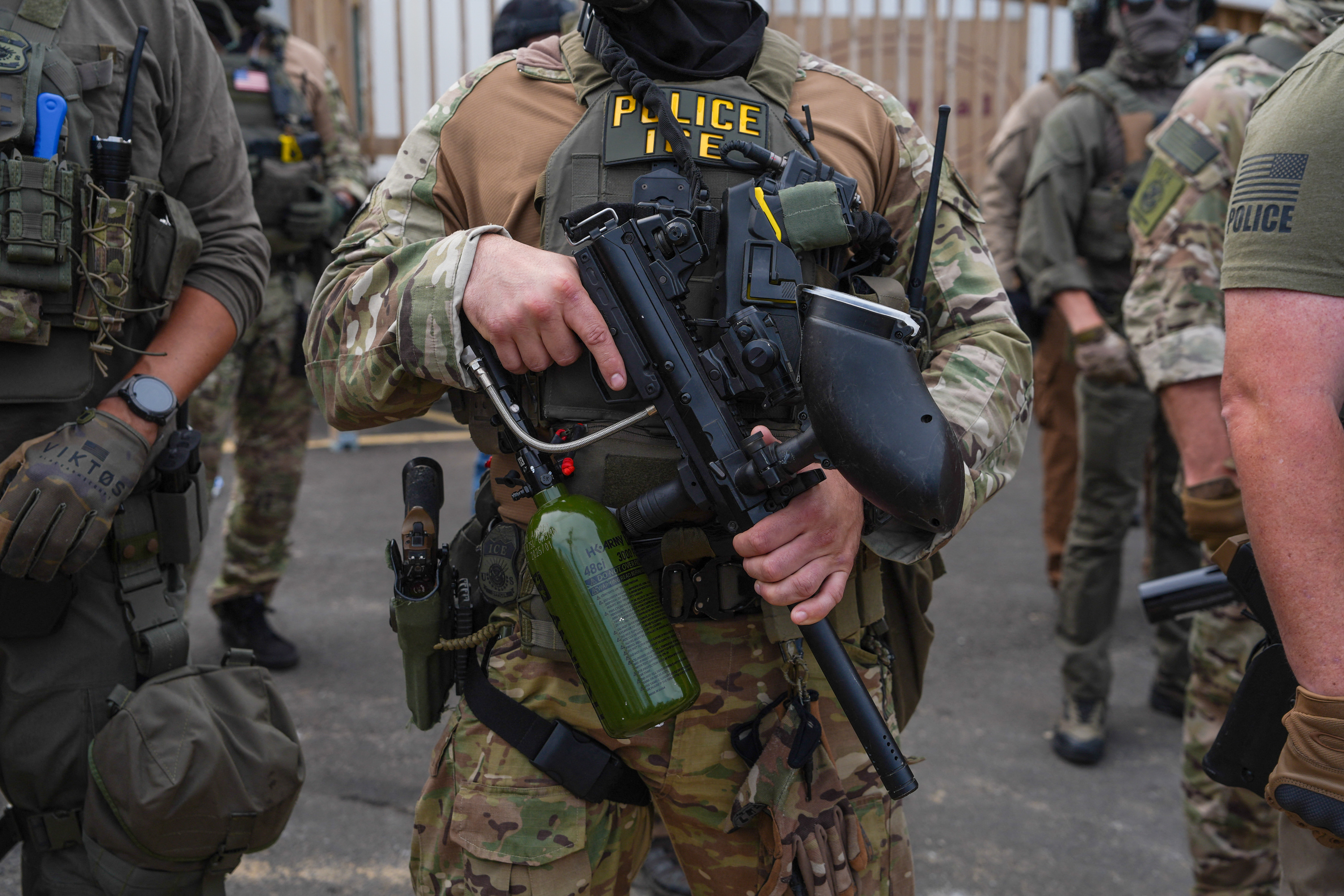 Immigration and Customs Enforcement agents stand guard holding less-lethal weapons as protesters gather outside Delaney Hall, which is being used as an ICE detention center, in Newark, New Jersey, on June 6, 2026.