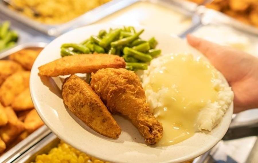 A plate of the “country’s best chicken” is served up alongside mashed potatoes and gravy, potato wedges and green beans at an unnamed Pizza Ranch location. | Courtesy Pizza Ranch